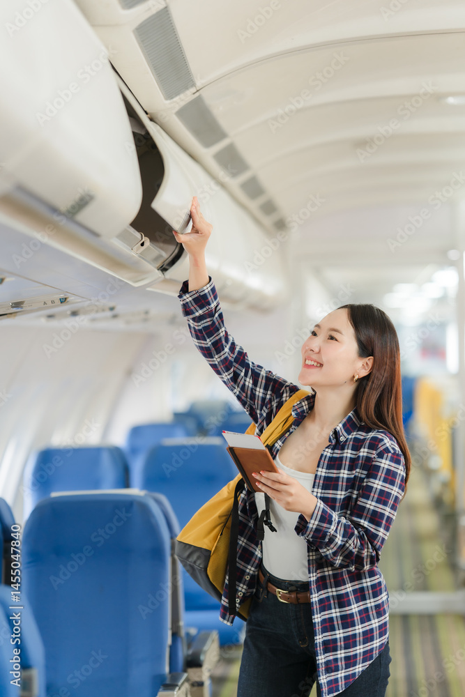 Asian Woman Stowing Luggage on Airplane