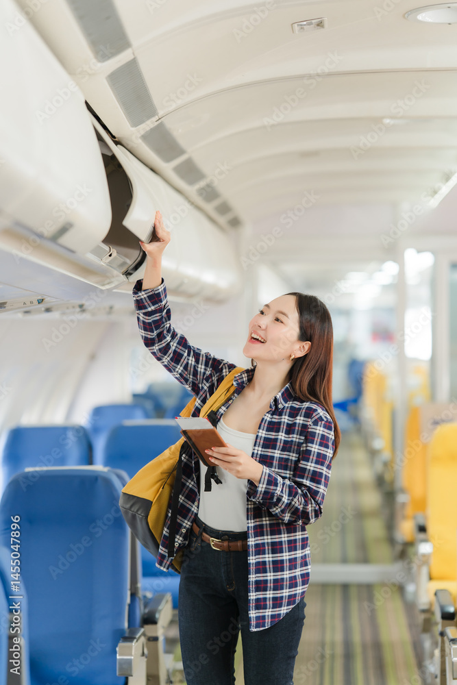 Asian Woman Stowing Luggage on Airplane