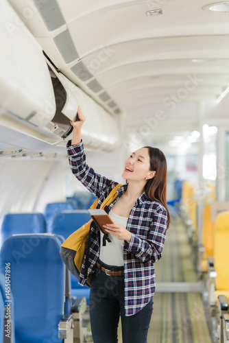 Obraz na płótnie Asian Woman Stowing Luggage on Airplane w salonie
