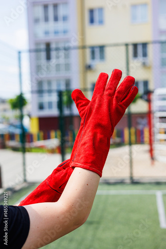 Obraz na płótnie Rough gloves on men's hands for a construction worker. Construction gloves. Durable gloves for dirty work. Garden gloves. Rubberized construction gloves. w salonie