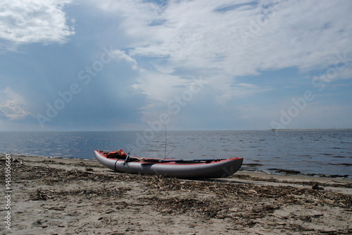 kayak on the shore of the white sea against the backdrop of a stormy sky