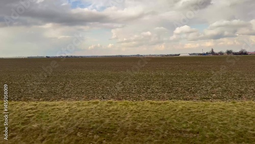 An Expansive Agricultural Landscape Stretching Under a Vast and Cloudy Sky Above