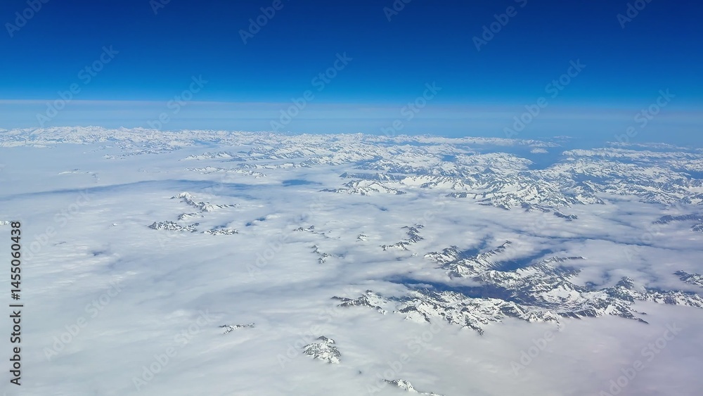 Stunning and Breathtaking Aerial View of SnowCapped Mountains Beneath a Clear Blue Sky Stunning and Breathtaking Aerial View of SnowCapped Mountains Beneath a Clear Blue Sky