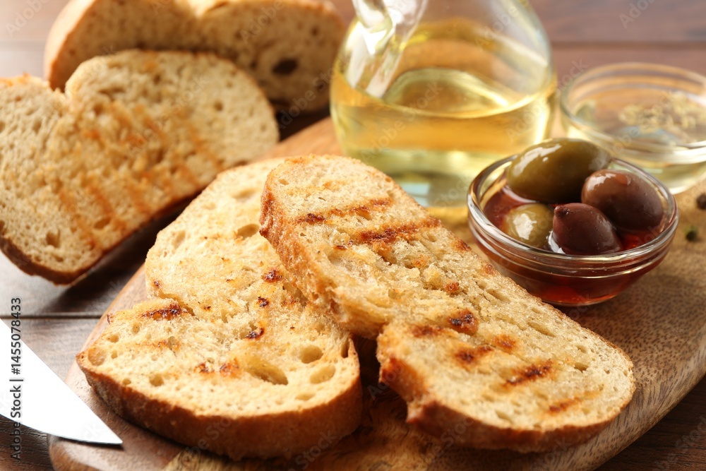 Toasted bread with oil and olives on table, closeup Toasted bread with oil and olives on table, closeup