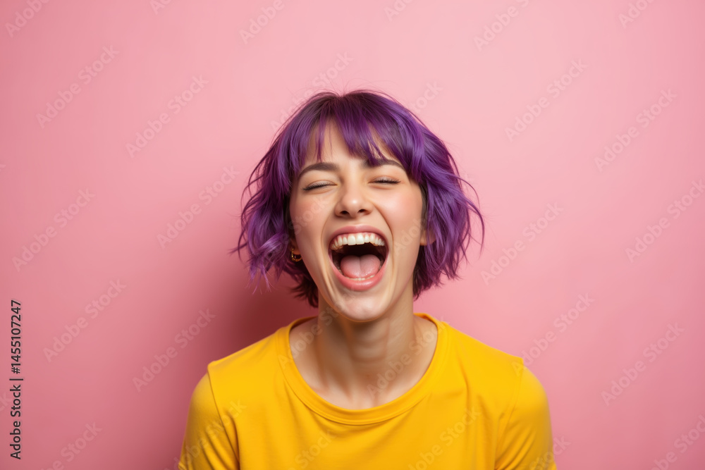 A woman with vibrant purple hair is laughing heartily, wearing a yellow shirt against a pink background.