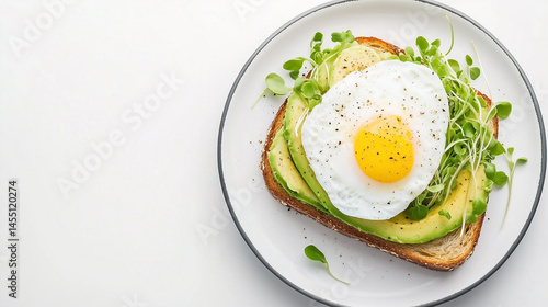 Avocado Toast with Fried Egg and Microgreens on White Plate
