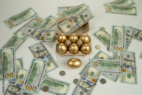 Golden eggs against a background of scattered dollars.