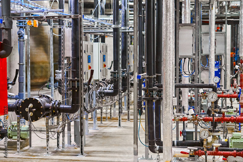 Detailed Interior View of a Complex Industrial Piping and Plumbing System within a Manufacturing Facility.
