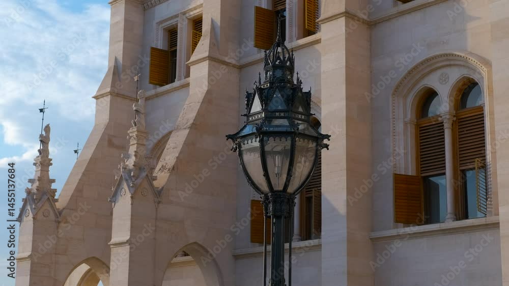 Old street lamp. Sunlight gliding across the ornate facade of a building highlights a decorative lamppost in front, creating a beautiful interplay of light and shadow in an urban setting Old street lamp. Sunlight gliding across the ornate facade of a building highlights a decorative lamppost in front, creating a beautiful interplay of light and shadow in an urban setting