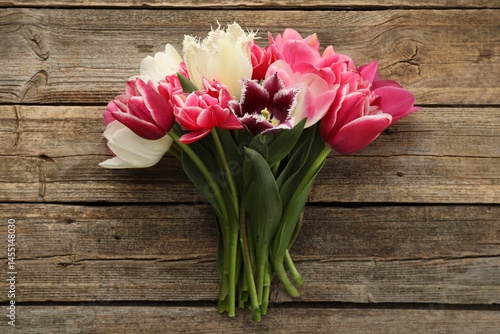 Beautiful tulips on wooden background, top view