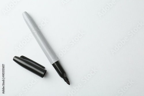 One black marker on light background, top view. Space for text
