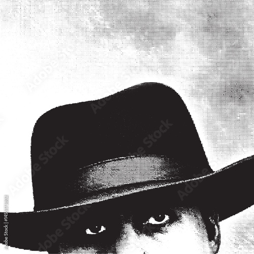 A man wearing a dark fedora gazes intently into the distance.