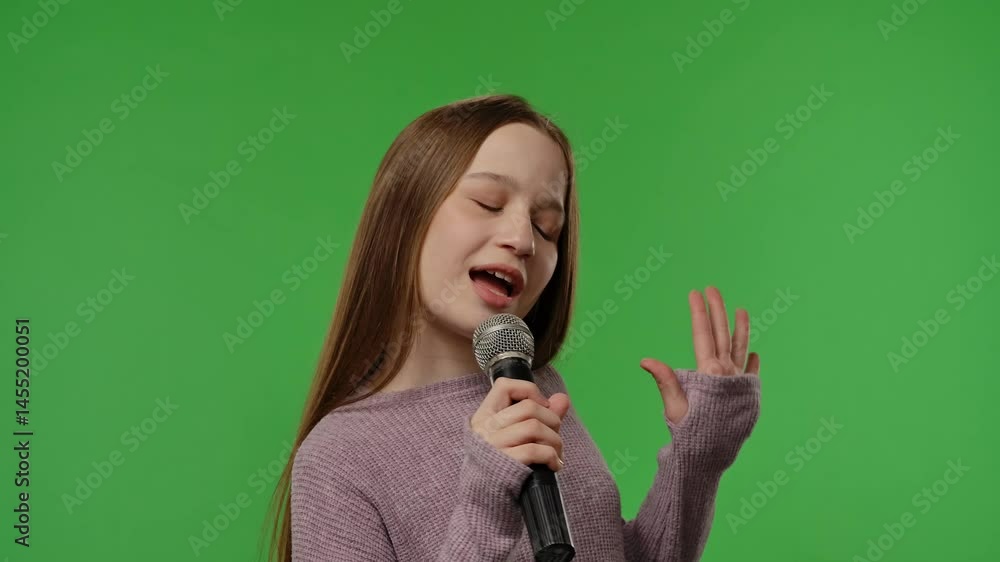 Teenage girl posing at camera smiling and singing song in karaoke microphone, positive expression, isolated on chroma key green screen studio background mockup. Teenage girl posing at camera smiling and singing song in karaoke microphone, positive expression, isolated on chroma key green screen studio background mockup.