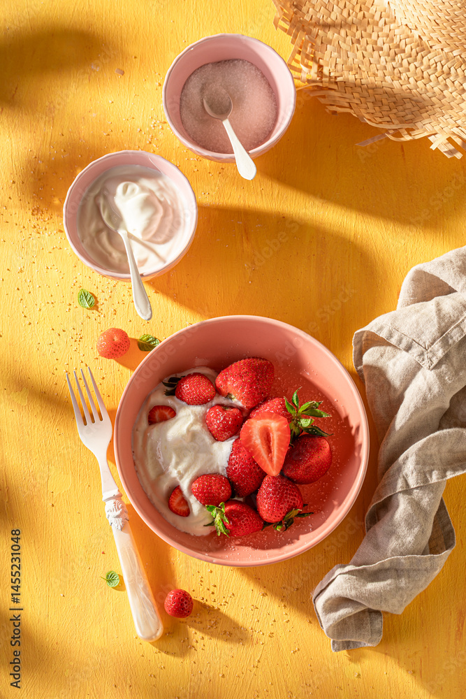 Fresh and sweet strawberries with cream and sugar.