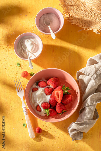 Fresh and sweet strawberries with cream and sugar.