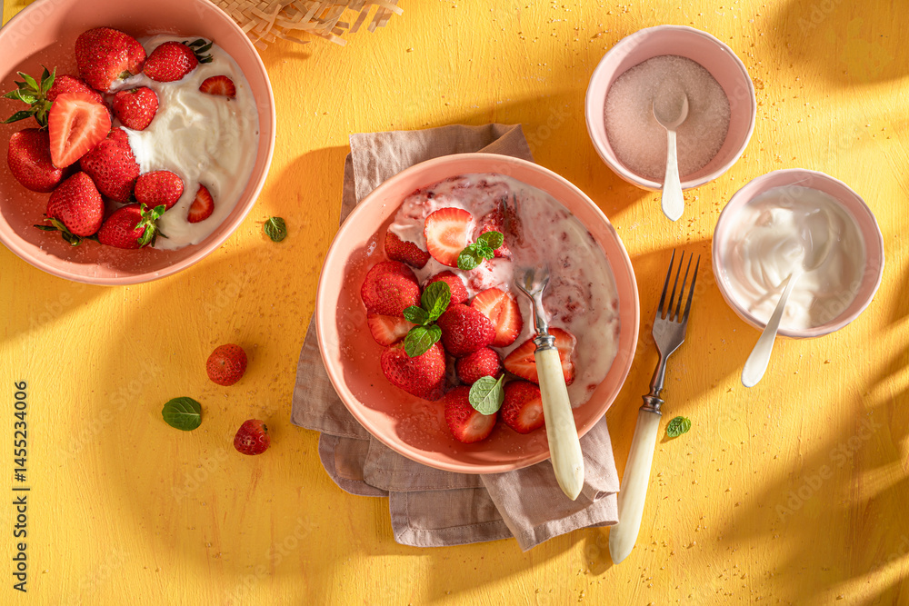 Tasty and homemade strawberries with cream and sugar.