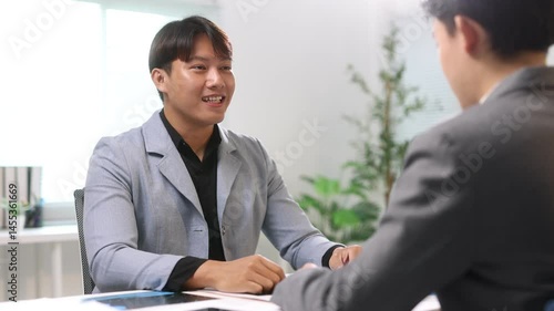 Wallpaper Mural Two businessman are discussing and shaking hands during a meeting in the office. They are smiling and looking happy with the agreement. Torontodigital.ca