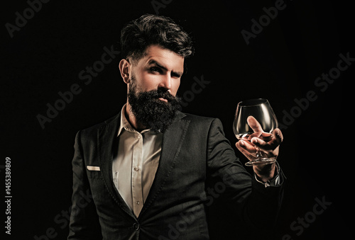 Whiskey glass held by bearded man. Guy drinking whiskey alone at bar. Whiskey pour in classic vintage glass. Whiskey tasting with retro style. Expensive whisky. Cognac or whisky. Alcoholic beverage.