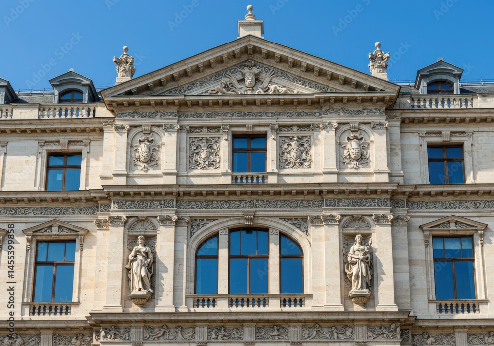 Obraz premium Facade of an ornate building with sculptures and blue windows on a sunny day