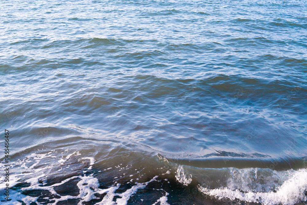 Fototapeta premium Rough seas and crashing waves in motion blur creating a dynamic texture of stormy surface of the ocean, ocean water background.
