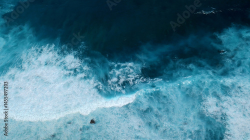 Fototapeta Naklejka Na Ścianę i Meble -  Seascape dark ocean background wave splash on rock. Tropical sea beach in summer seaside outdoor. Water Surface blue wave pattern. Turquoise ocean sea water white wave pattern splashing deep blue sea