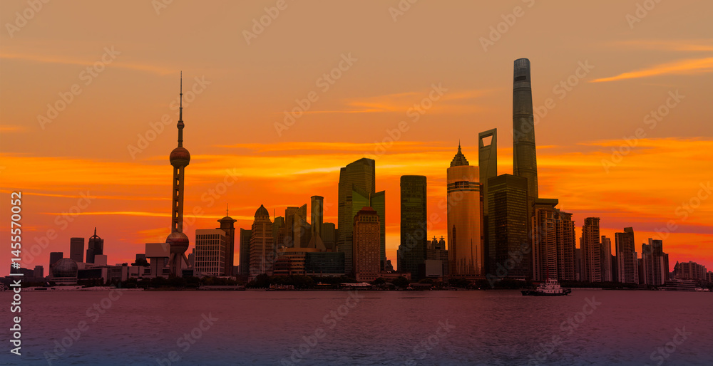 Obraz premium Shanghai colorful skyline with motion speed light of passing ferry in the foreground at sunset - Shanghai, China