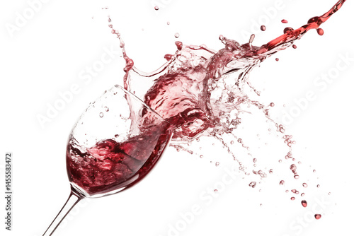 Close up of a wine glass with red wine splashing out against a black background in a dynamic motion shot