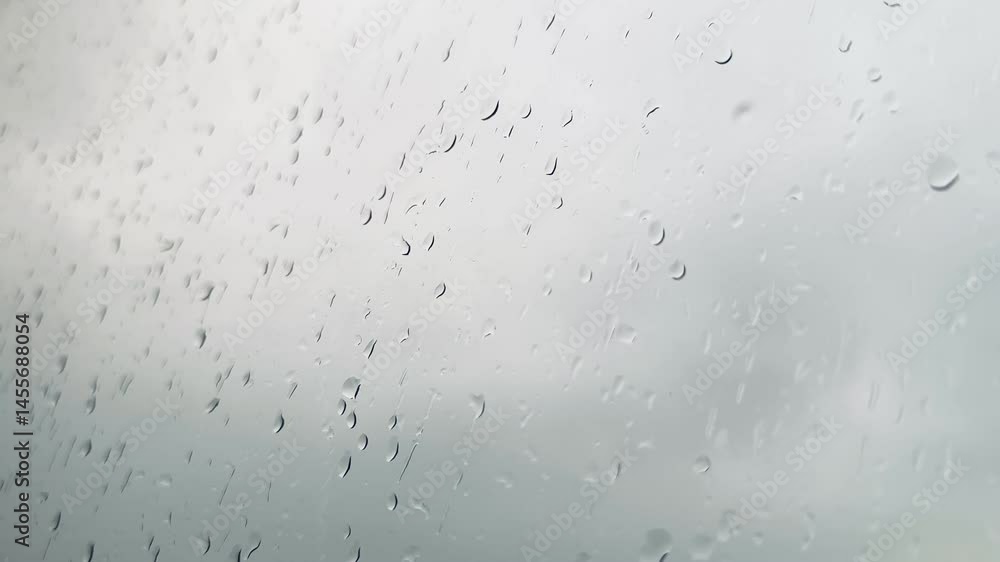 Raindrops in macro, focus in the middle, against gray sky background in the background 60fps