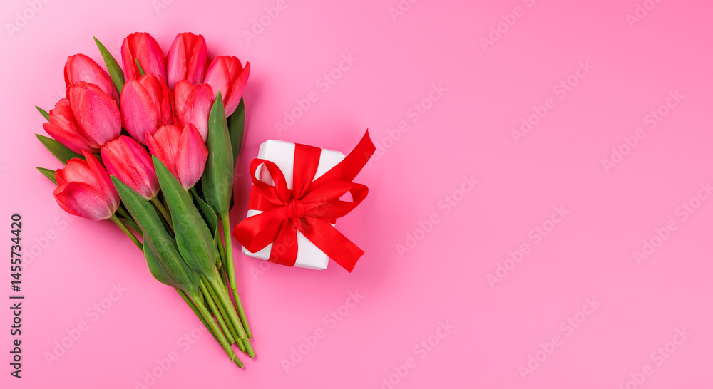 Fototapeta premium Pink tulip bouquet and gift box on a soft pink background