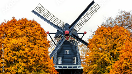 Autumnal windmill framed by vibrant foliage.  Black wooden windmill stands amid brilliant fall trees