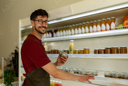 Fotografie Smiling shopkeeper arranging food products on shelves, creating an inviting disp