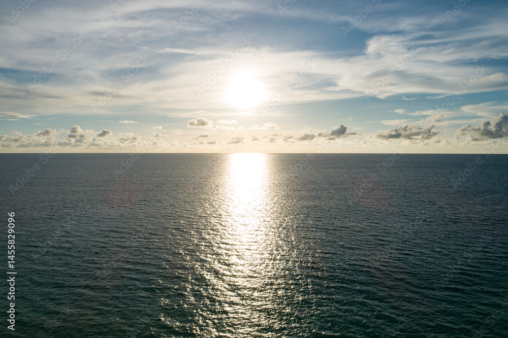 Obraz premium Aerial view of a blue sea surface water texture background and sun reflections Aerial flying drone view Waves water surface texture on sunny tropical ocean in Phuket island Thailand