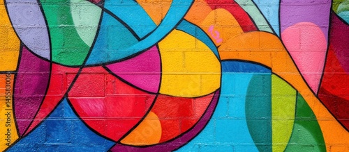 A vibrant mural of colorful abstract shapes on a brick wall.