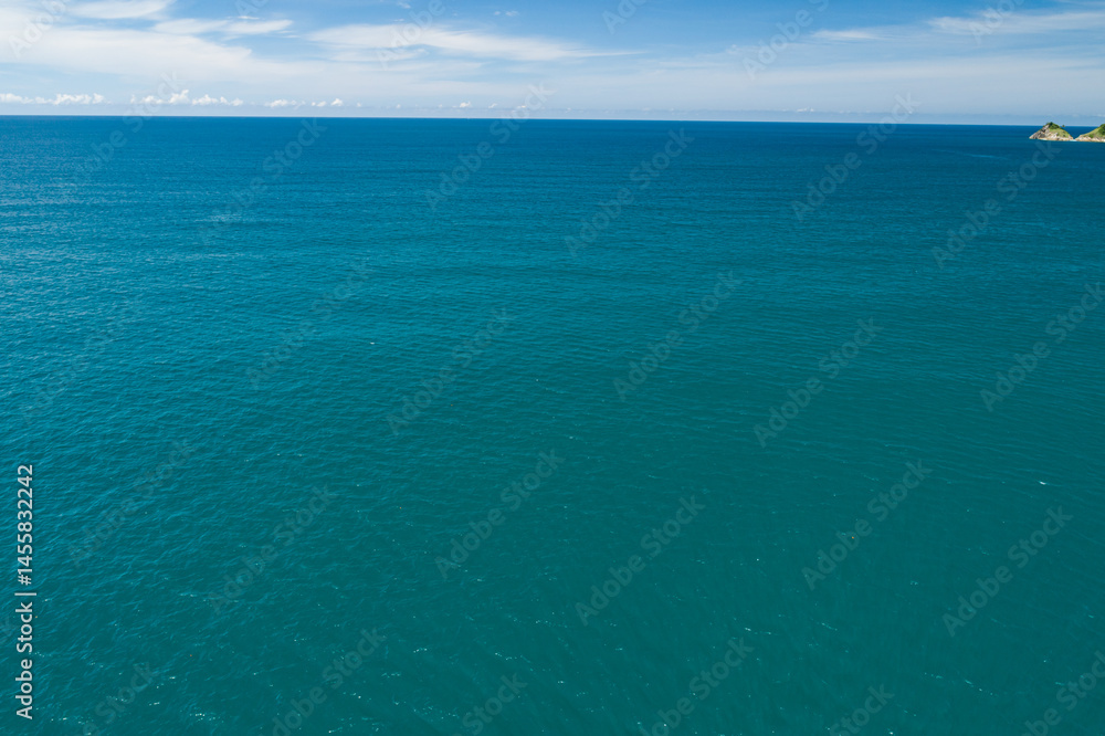 Obraz premium Aerial view of a blue sea surface water texture background and sun reflections Aerial flying drone view Waves water surface texture on sunny tropical ocean in Phuket island Thailand