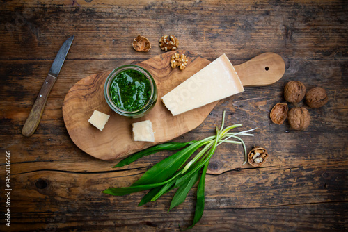 Wild garlic pesto with parmesan and walnuts on a rustic wooden table photo