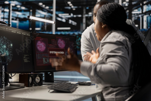Technicians in data center viewing hacking security breach alert of zero day exploit vulnerability. Cybersecurity colleagues doing brainstorming to trace intrusion origin and apply emergency patches