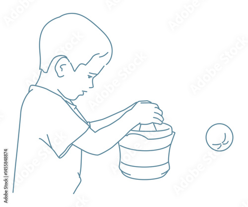 Young boy exerts himself to make juice from an orange using juice