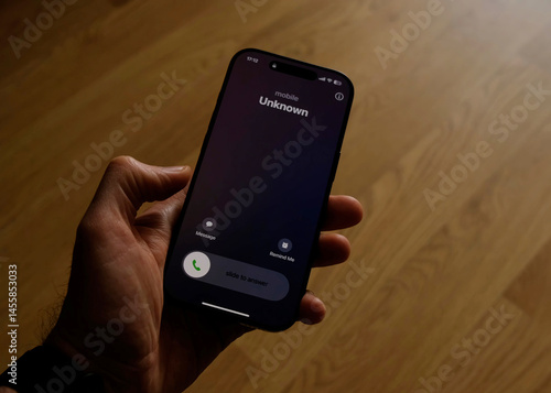 Fraud or fraudulent schemes. Close-up of a male hand holding a phone with an unexpected incoming call from an unknown