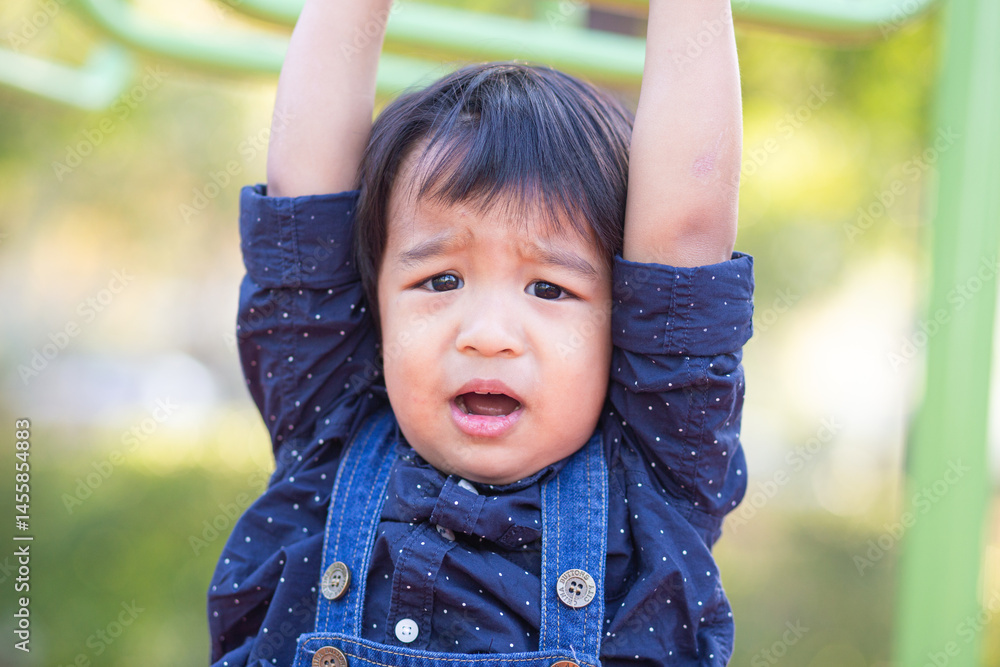 Adorable little asian 2 - 3 year boy climbing practice in playground outdoor