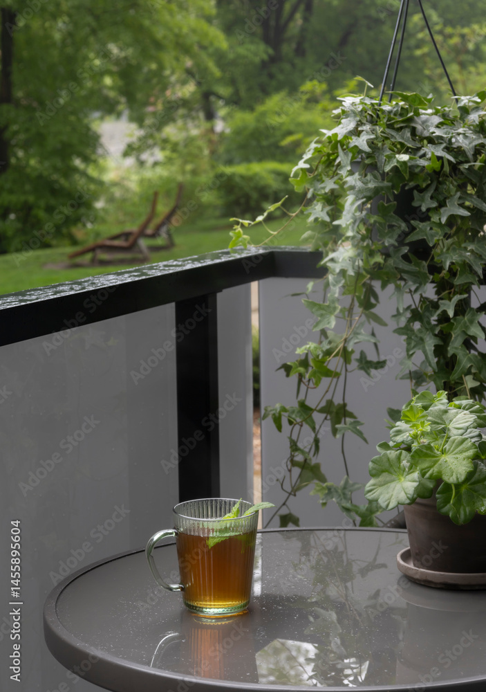 cup of black tea on balcony in rain