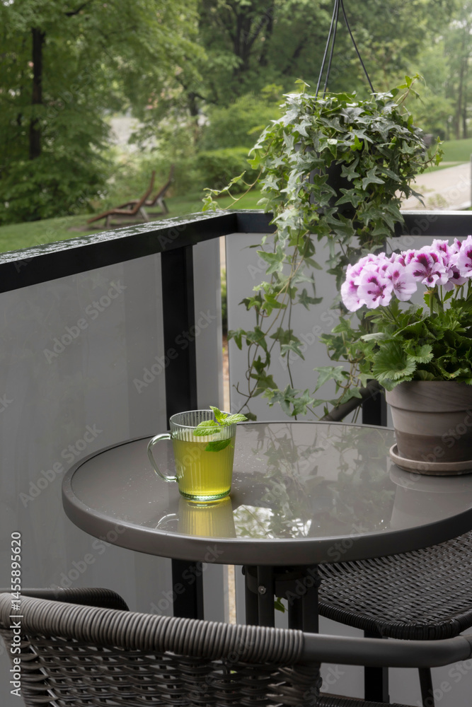 cup of green tea on balcony in rain