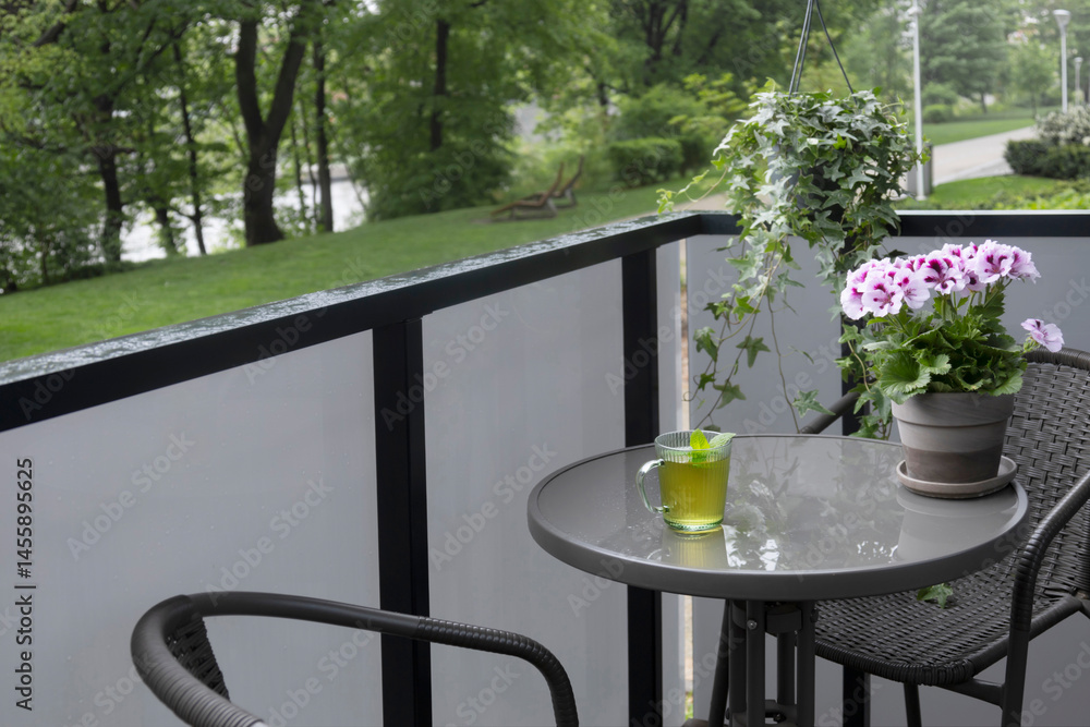 cup of green tea on balcony in rain