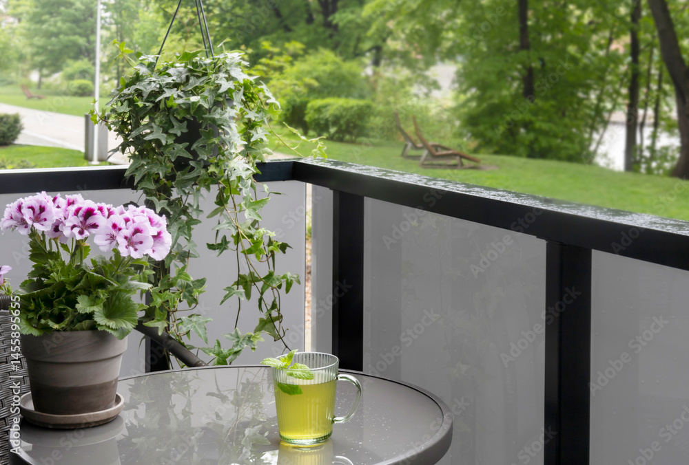 cup of green tea on balcony in rain