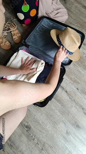 Packing a stylish suitcase with colorful clothes and essentials in a cozy setting, capturing moments of travel preparation