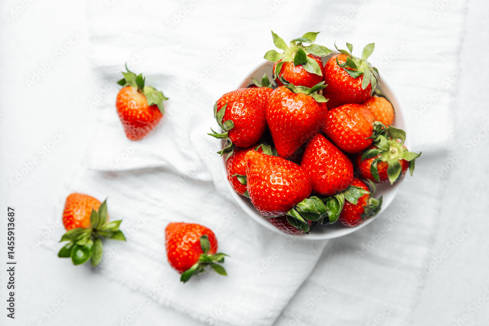 Fresh strawberries arranged in a bowl on a white linen cloth Fresh strawberries arranged in a bowl on a white linen cloth