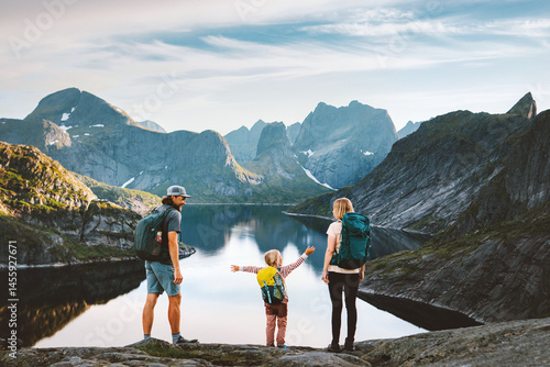 Family mother, father and child traveling in Norway parents hiking with kid in Lofoten islands active summer vacation outdoor, people tourist group enjoying lake and mountains healthy lifestyle tour