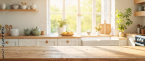 Empty wooden table with the bright white interior of the kitchen as a blurred background behind the bokeh golden sunshine