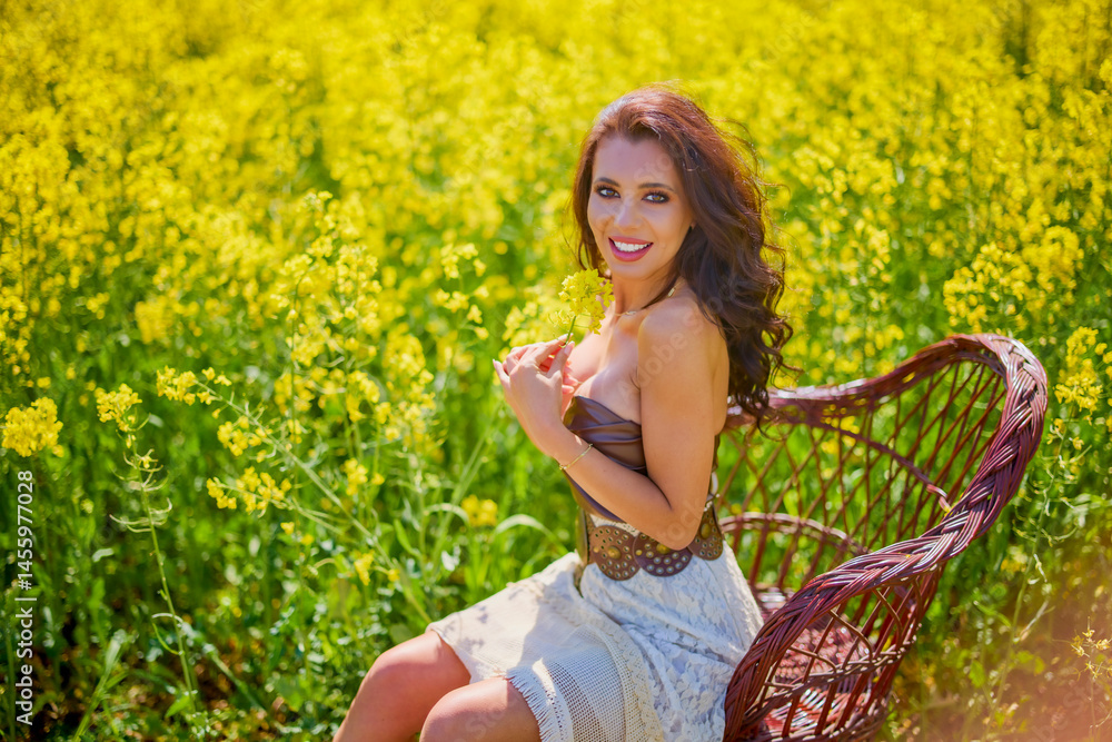 beautiful woman posing in a field of blooming rapeseed