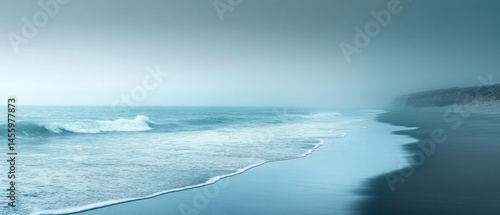 Ocean waves wash ashore misty beach, creating calming seascape with serene atmosphere.