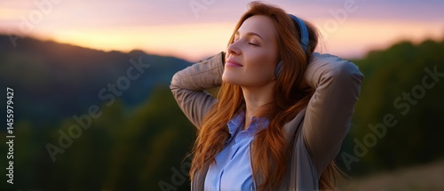 Obraz na płótnie A woman enjoys music with headphones outdoors at sunset, appearing relaxed and content, surrounded by nature. w salonie